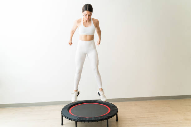 Attractive slim Caucasian female rebounding against wall during interval training at fitness studio